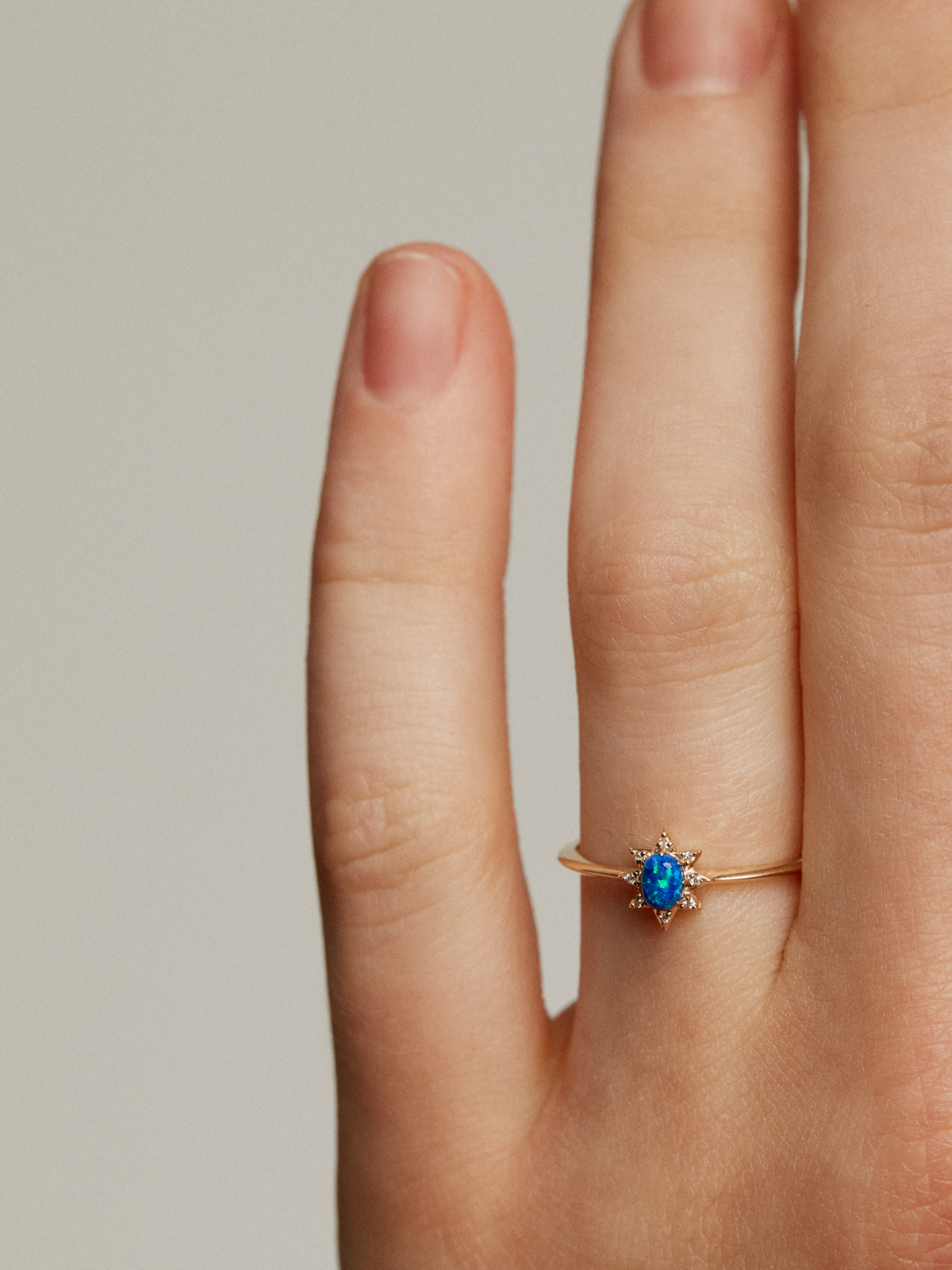 18K yellow gold ring with lab-grown blue opal and white diamonds.