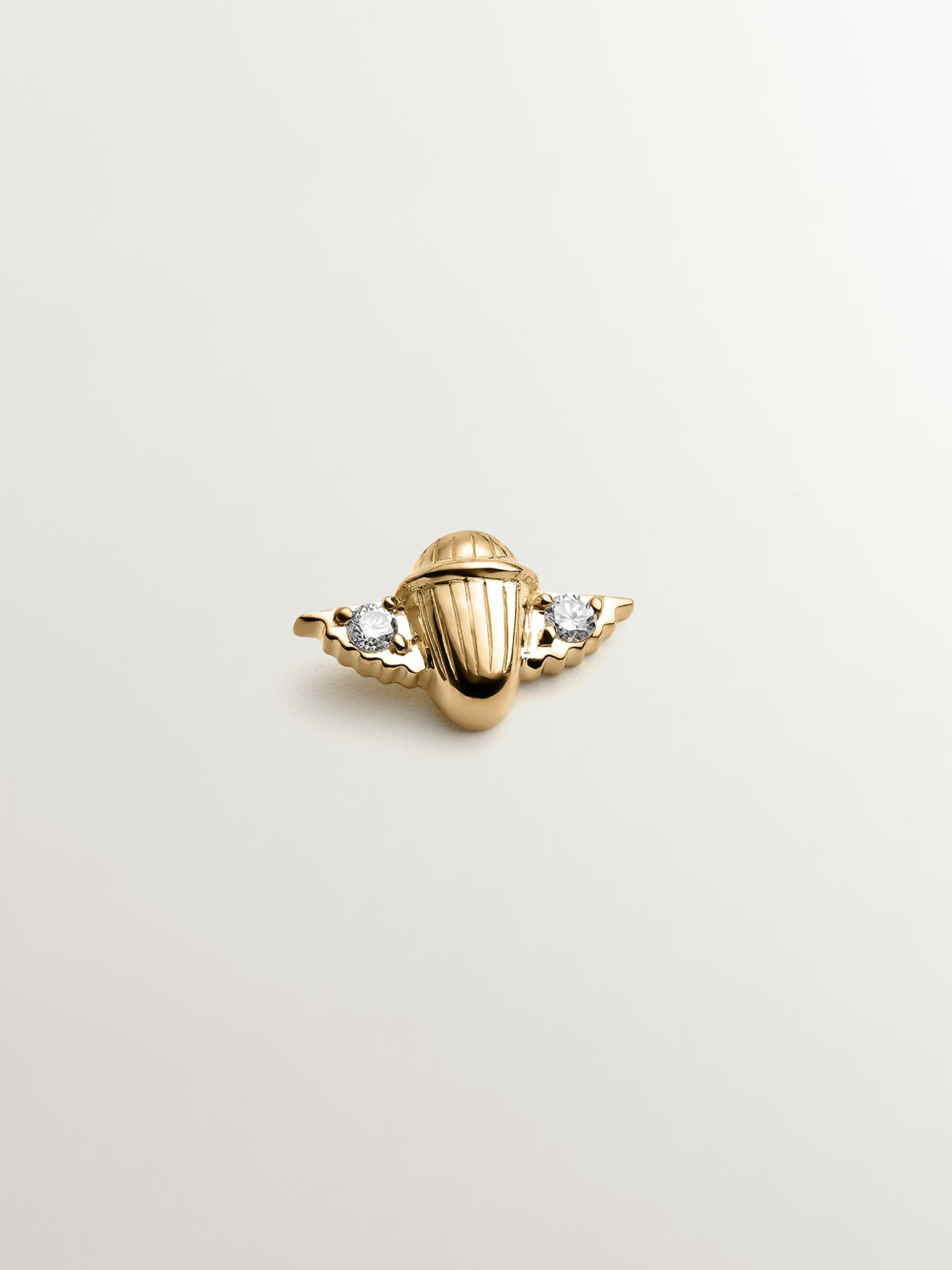 18K yellow gold piercing with diamonds in the shape of a beetle.