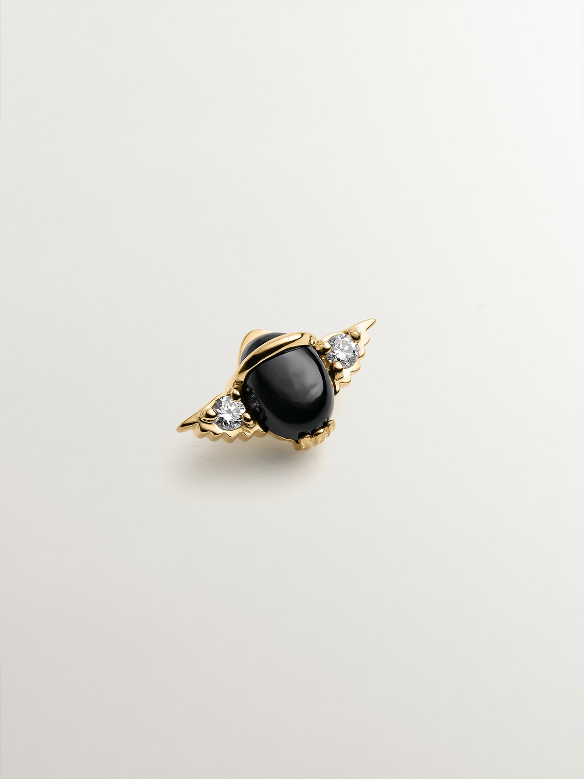 18K yellow gold piercing in the shape of a beetle with onyx and diamonds.