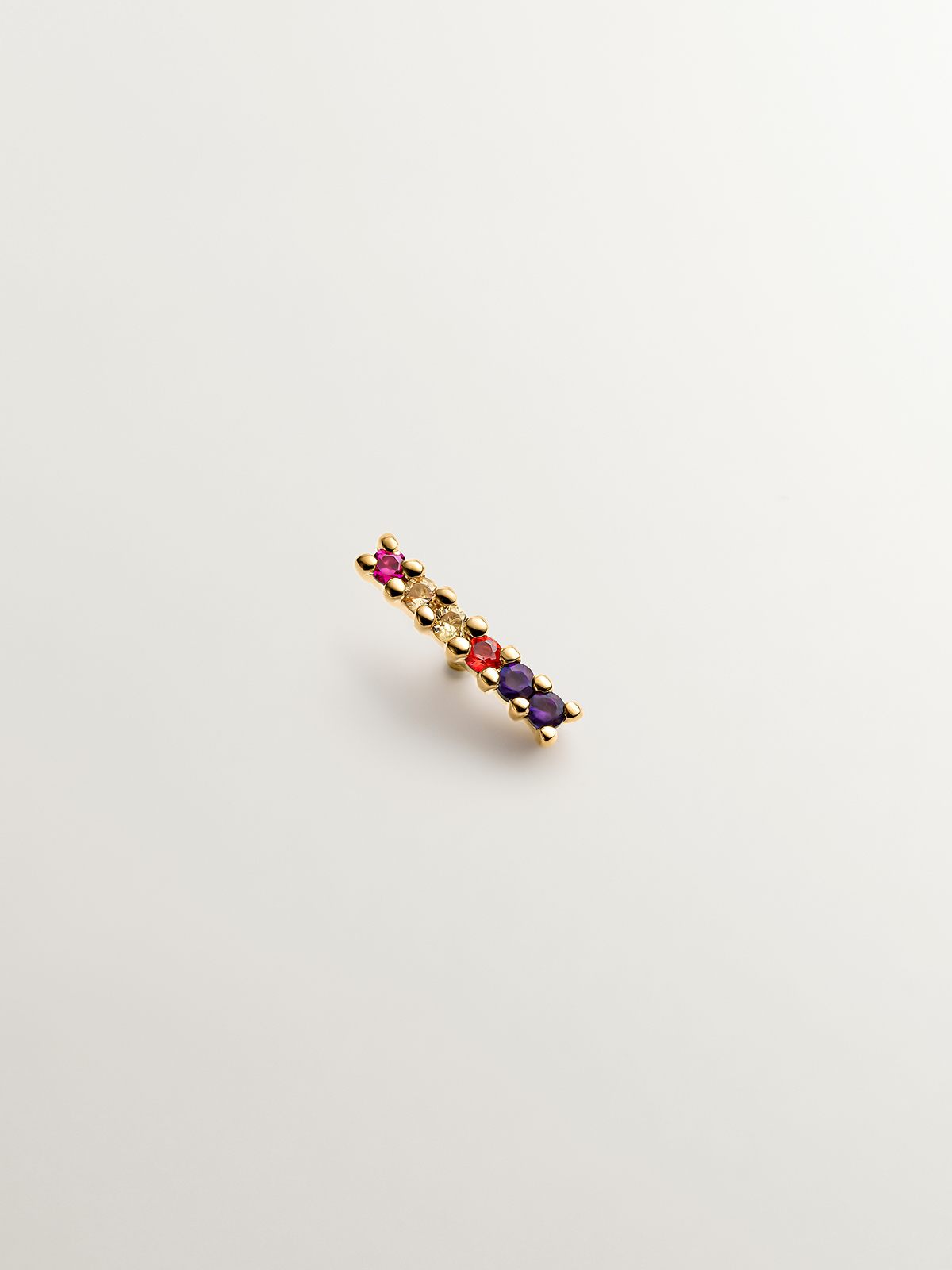 18K yellow gold line piercing with amethyst, ruby and multicolor sapphires.